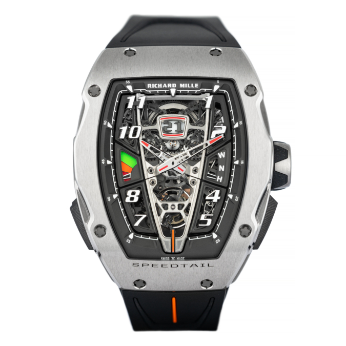 Richard Mille Mclaren speedtail has a titanium bezel, black rubber strap, skeleton dial. Oversize date display semi-instantaneous, horizontally placed under 12 o’clock, functioning via two skeletonised calendar discs over a white field.