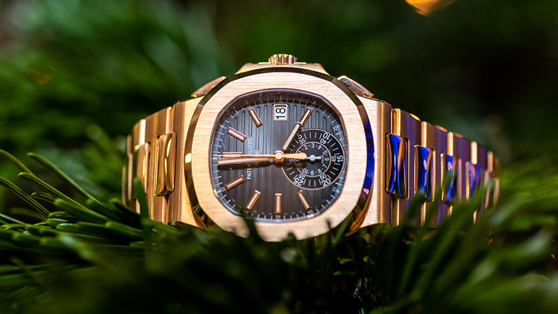 Close up of yellow gold Patek Philippe watch with dark dial